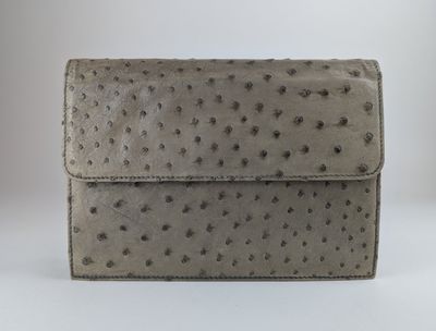 un portefeuille en cuir d'autruche gris avec une fermeture à rabat