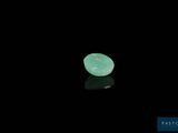 un gros plan sur un morceau de jade vert posé sur une surface noire