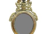 a gold mirror with a bird on it