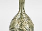 a green vase that is sitting on a white surface