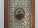 an old stained glass picture of a landscape in a wooden frame
