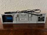 an electronic device sitting on top of a wooden table next to a wall