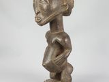a wooden statue of a woman with a hat on her head