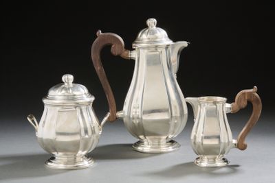 three pieces of silver tea and coffee set on a table