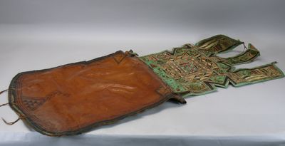 un vieil étui en cuir orné d'une croix, posé sur une surface blanche