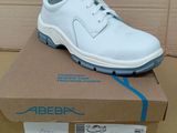 la chaussure est blanche et bleue, posée sur une boîte en carton