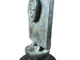 sculpture of a face on a stone base with a white background