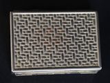 a silver box with a pattern on it on a black surface