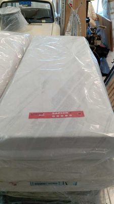 a stack of mattresses sitting on top of a cart in a warehouse