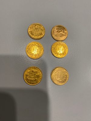 quatre pièces d'or posées sur une surface blanche