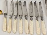 six knives and a bowl of fruit on the table
