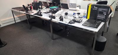 un bureau sur lequel se trouvent un ordinateur portable, un écran et d'autres appareils électroniques