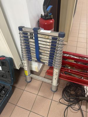 une échelle posée par terre à côté d'une borne d'incendie