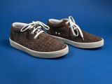brown sued sneakers with white laces on a blue background