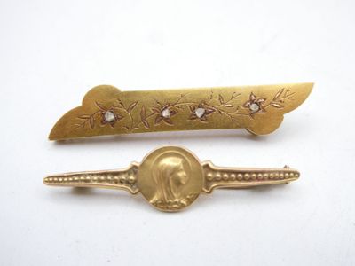 pair of gold tone hair clips with a picture of a woman on it