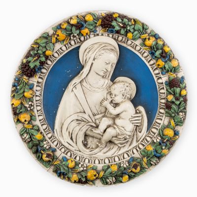 a close up of a plate with a statue of a woman holding a baby