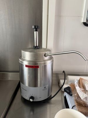 une cafetière posée sur le plan de travail, à côté d'un bol de pain