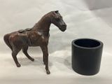 une statue de cheval à côté d'un vase noir