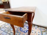 une petite table en bois surmontée d'un tiroir