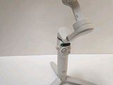 a small white object on a tripod with a remote control
