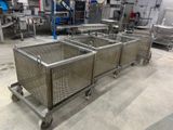 four metal bins on wheels in a large room