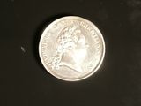a close up of a silver coin on a black surface