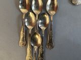 five spoons and two spoon spoons hanging on a wall
