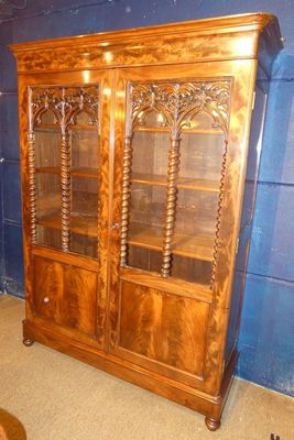 un grand meuble en bois avec des portes en verre dans une pièce