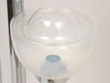 a close up of a glass vase on a metal stand