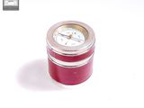 a small red clock sitting on top of a white table