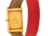 an image of a gold watch with a red leather band