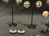 five pairs of earrings that are sitting on a stand