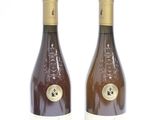 two bottles of wine sitting next to each other on a white surface