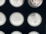 six different silver coins in a display case with a black background