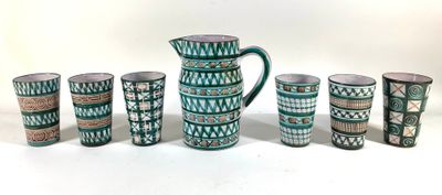 five cups and a pitcher sitting next to each other on a table