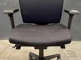 une chaise de bureau avec une assise noire et des roulettes noires