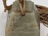 a stone object with a rope around it on a white surface