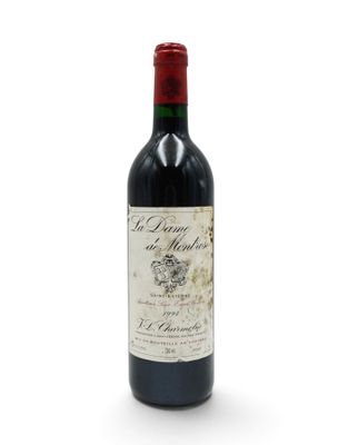 a bottle of red wine sitting on top of a white table