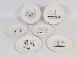 four white plates with black and white illustrations on them on a white surface