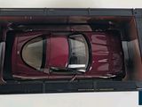 a red toy car in a black box on a white surface