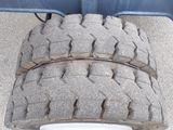 a tire that is sitting on the ground next to a wheel