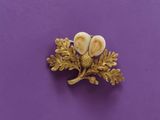 a close up of a gold brooch with two hearts on it