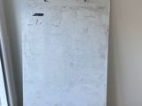 a white board on the easel in the corner of a room