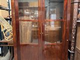 un meuble en bois avec une porte en verre dans une pièce