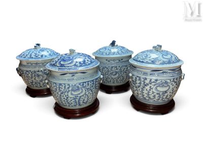 quatre vases bleus et blancs avec couvercle, posés sur des socles en bois