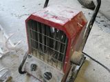 un petit radiateur portable posé par terre dans un garage