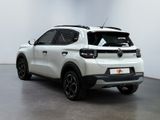 the rear view of a white suv parked in a white room