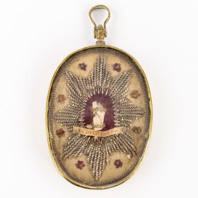 an antique gold locke with a picture of a woman and a cat
