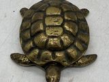une tortue dorée sur un fond blanc, avec une inscription en chinois