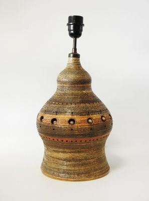 une image représentant un vase marron et noir percé de trous